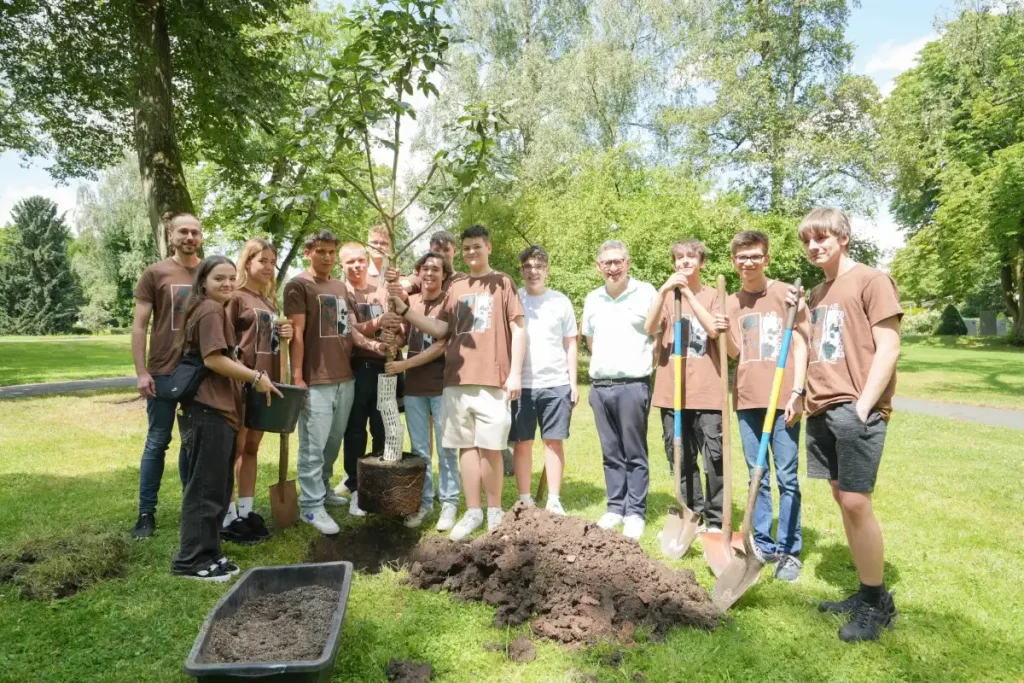 Schülerinnen und Schüler pflanzen Rosskastanie im Festspielpark